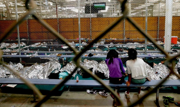 Two girls watching a World Cup soccer game from inside an immigration detention center in Brownsville, Texas. (Ross D. Franklin-Pool/Getty)